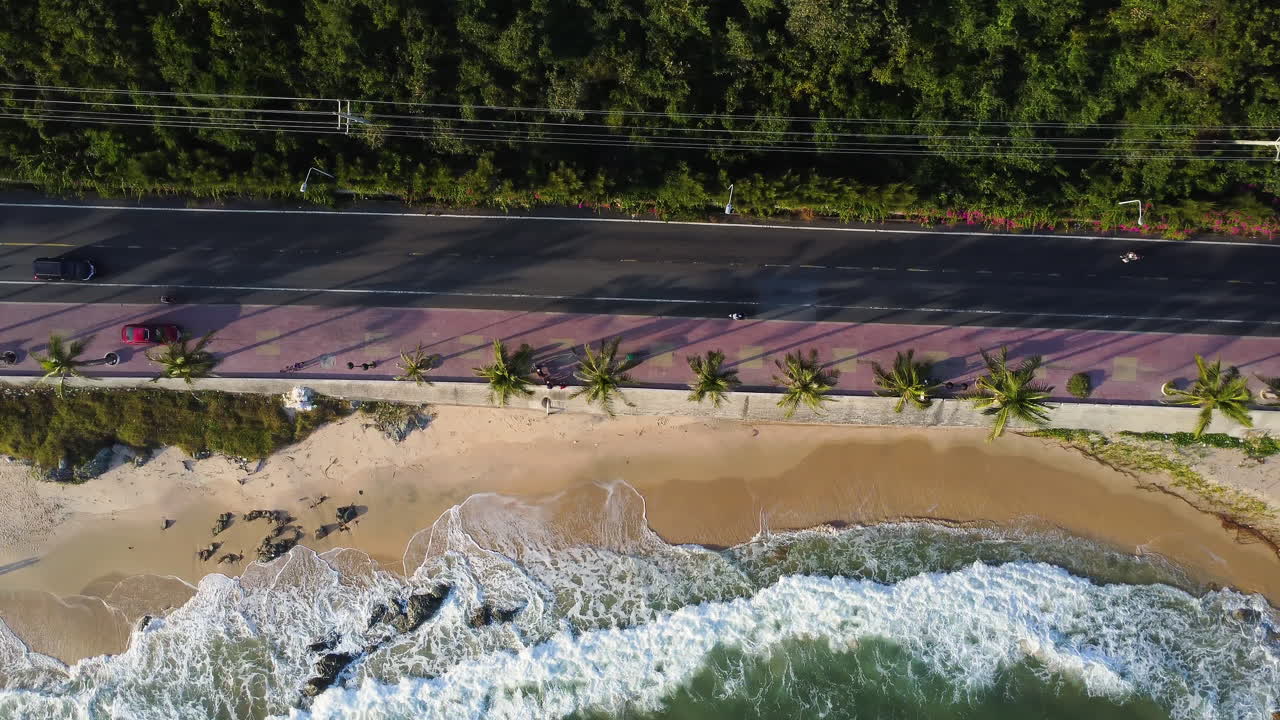 antena de arriba hacia abajo, coches conduciendo por carretera por la costa de la playa tropical