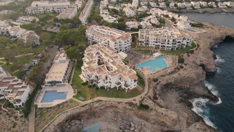 Fixed-top-view-aereal-over-touristic-houses-and-settlement-near-the-coastline,-captured-during-daytime-at-Mallorca,-Spain