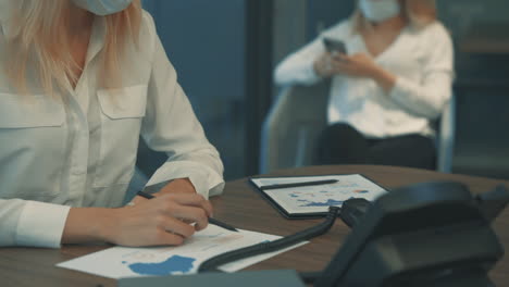 Mujer-Con-Mascarilla-Trabajando-Con-Documentos-Comerciales-Con-Cuadros-Y-Gráficos