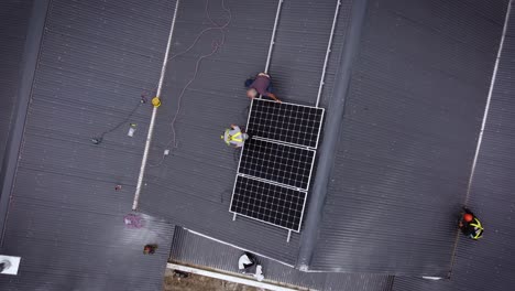 roofers are installing solar panels on roof of house - top down view