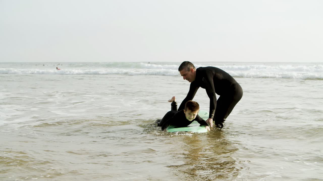 padre enseñando a su hijo a surfear en el océano