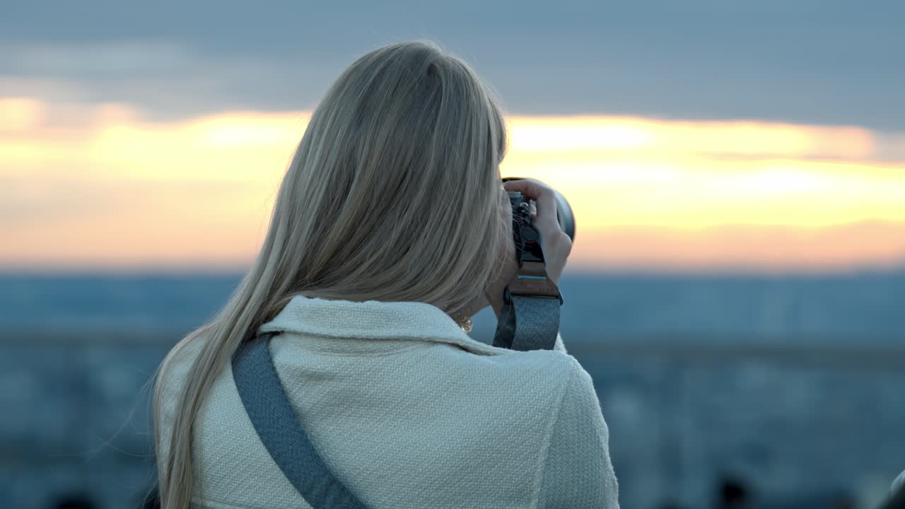 A photographer captures the breathtaking beauty of Tokyo during sunset. The vibrant sky and glowing cityscape provide a perfect backdrop, showcasing the stunning blend of nature and urban life.
