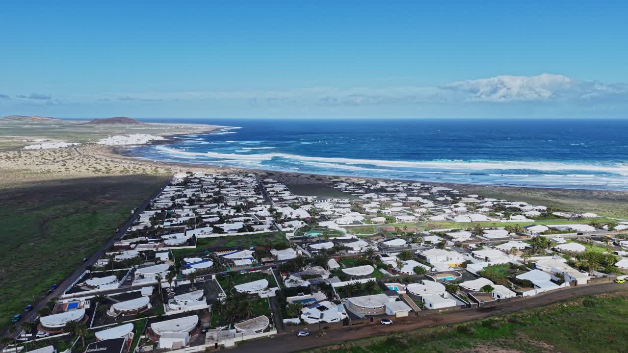 Vista de frente para o mar de casas em Lanzarote, Espanha, com ondas do oceano