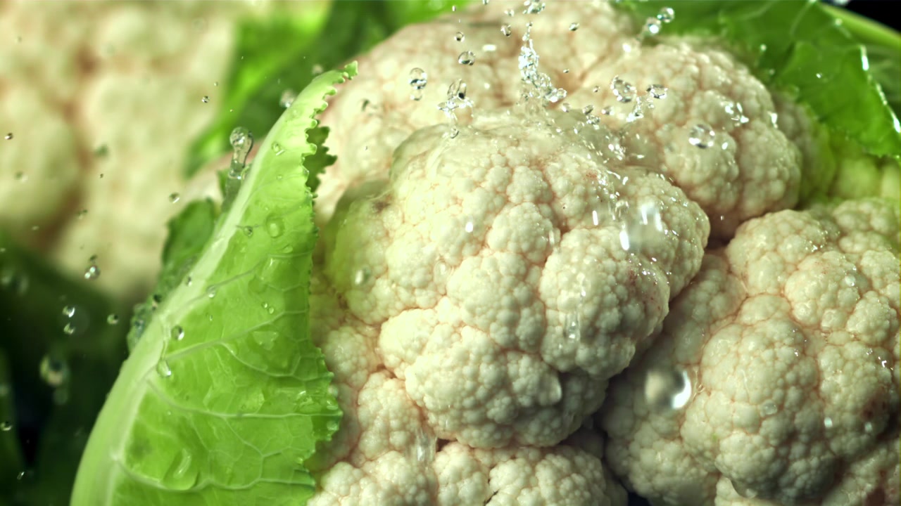 Frischer Blumenkohl wird in Zeitlupe mit Wasser gewaschen