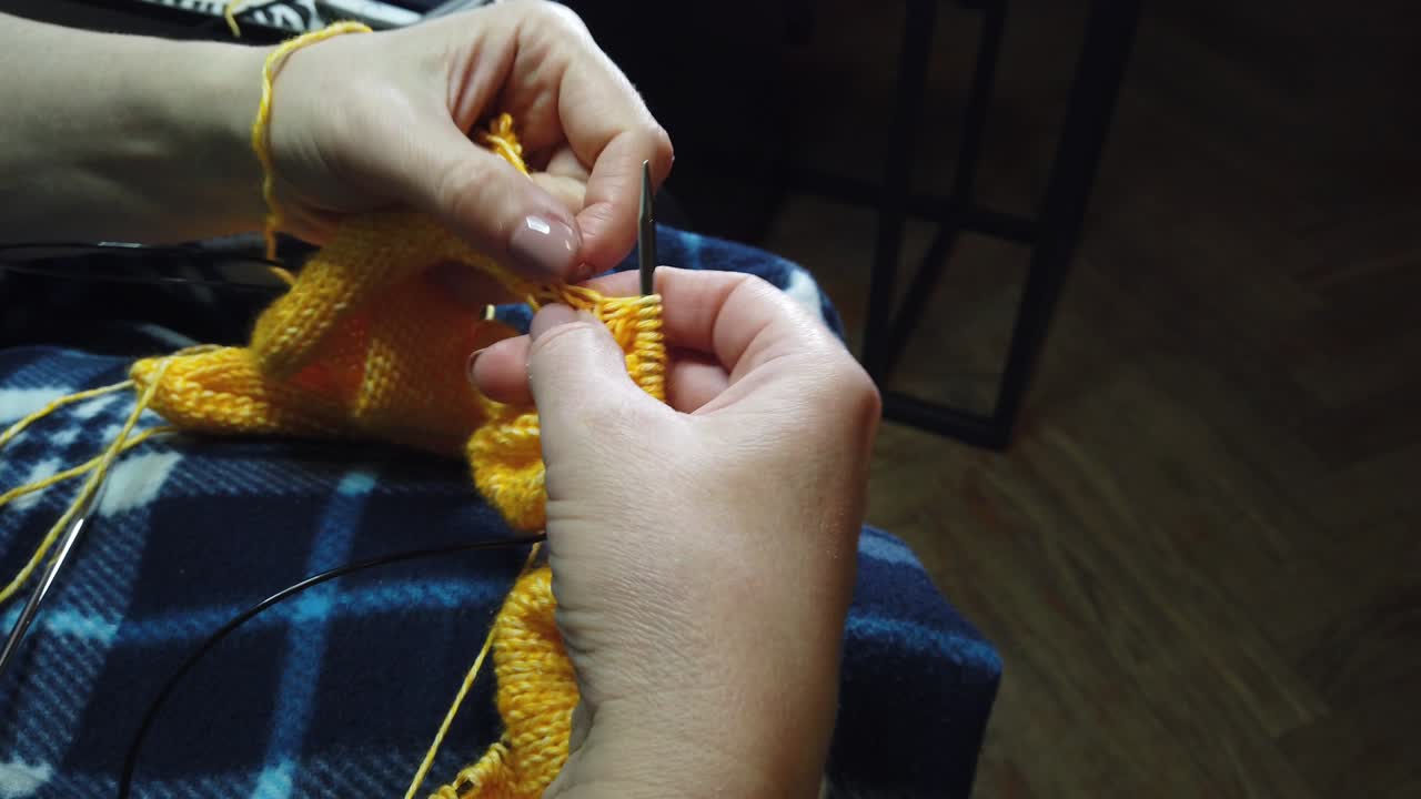 여성의 손은 뜨개질 바늘과 함께 양털 재을 니다.  뷰, 손과 뜨개짐의 클로즈업.