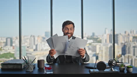 happy businessman throwing documents enjoying success. smiling manager reading