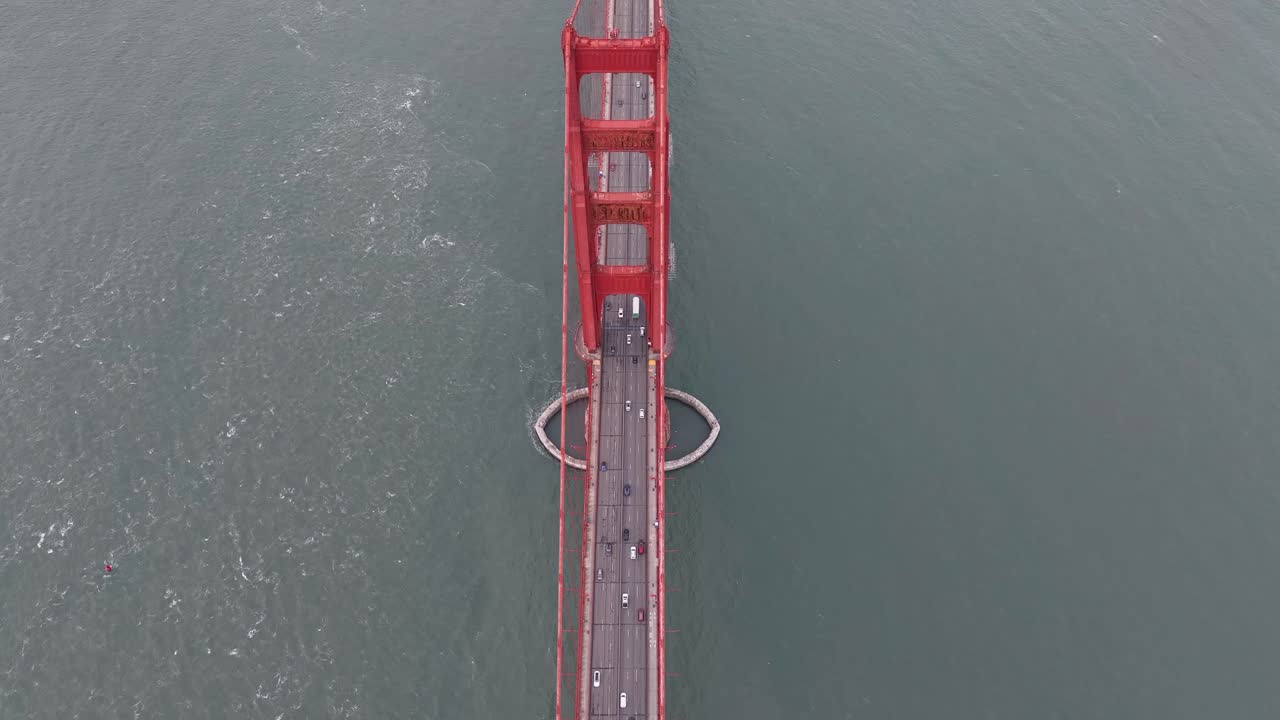 Aerial above traffic and Golden Gate Bridge tower and San Francisco Bay