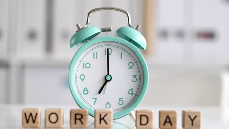 text working day and alarm clock at seven o'clock on desktop