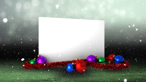 Animation-of-snow-falling-over-white-card-with-copy-space-and-christmas-decorations