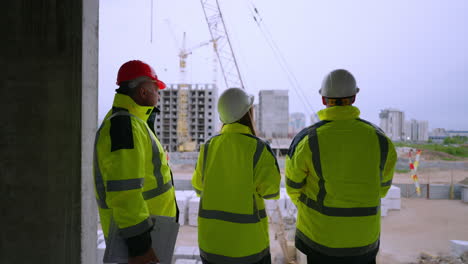 tres ingenieros civiles están observando el proceso de construcción de edificios en el área residencial de la ciudad
