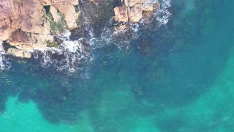 Nature's-Palette:-Aerial-View-of-Rocky-Shores-Meeting-Azure-Waters