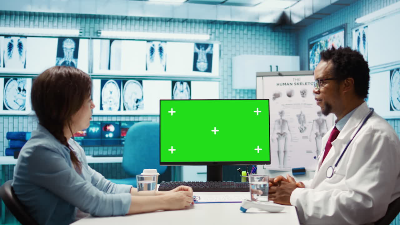 아프리카계 미국인 의료 전문가가 환자와 함께 복사 공간 화면을 보고 있습니다.