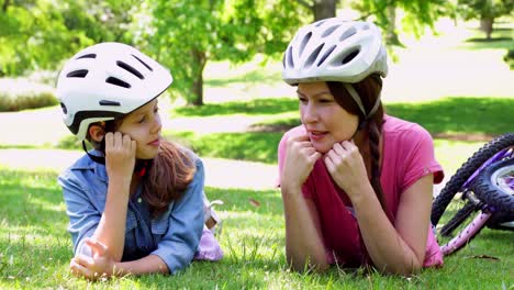 madre e hija tomando un descanso en su paseo en bicicleta en el parque