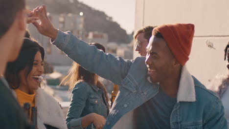 slow-motion-multi-ethnic-friends-enjoying-rooftop-party-celebration-dancing-together-enjoying-summer-vacation-drinking-alcohol-celebrating-on-sunny-weekend-in-urban-city-at-sunset