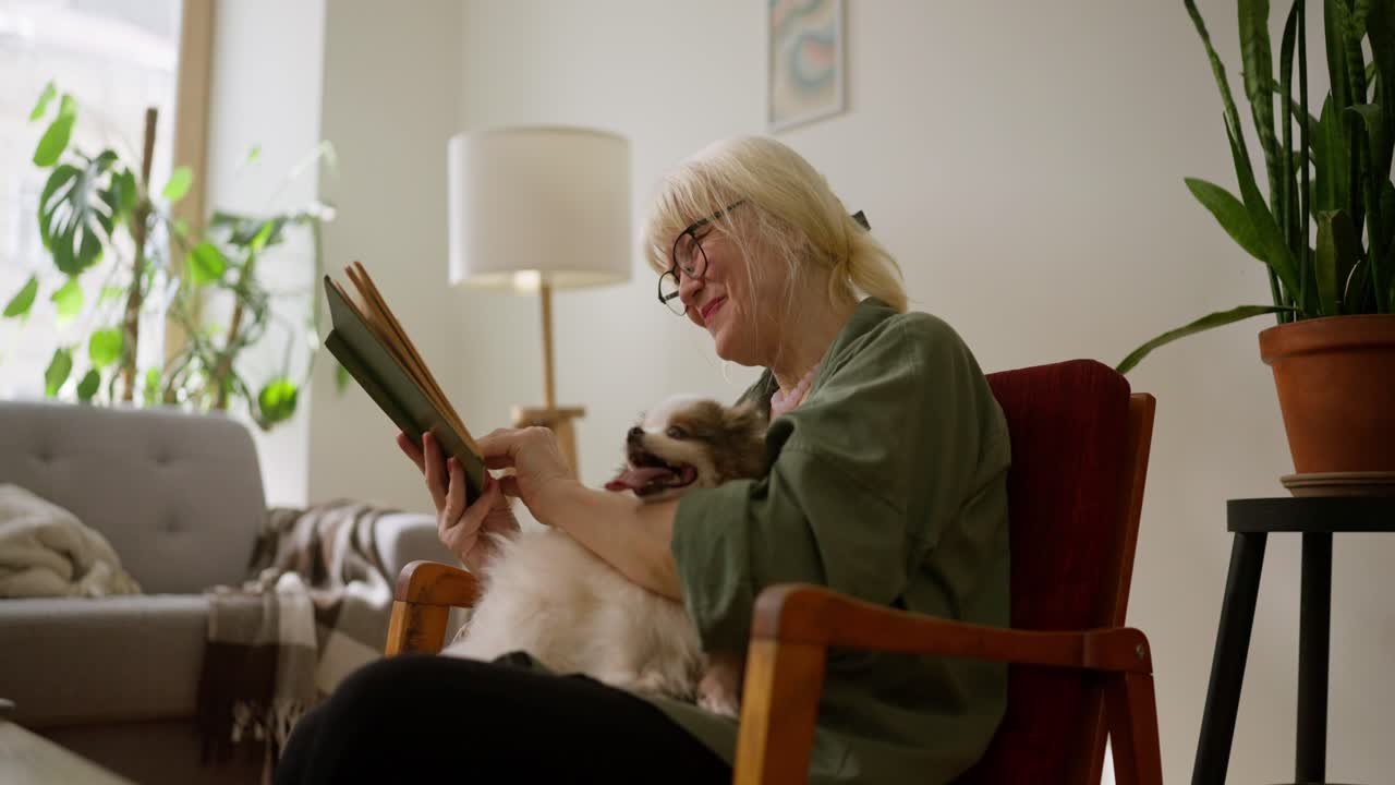 Senior Woman Reading with Dog at Home