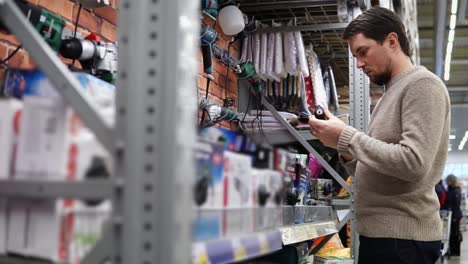 man shopping for tools and electronics in a hardware store