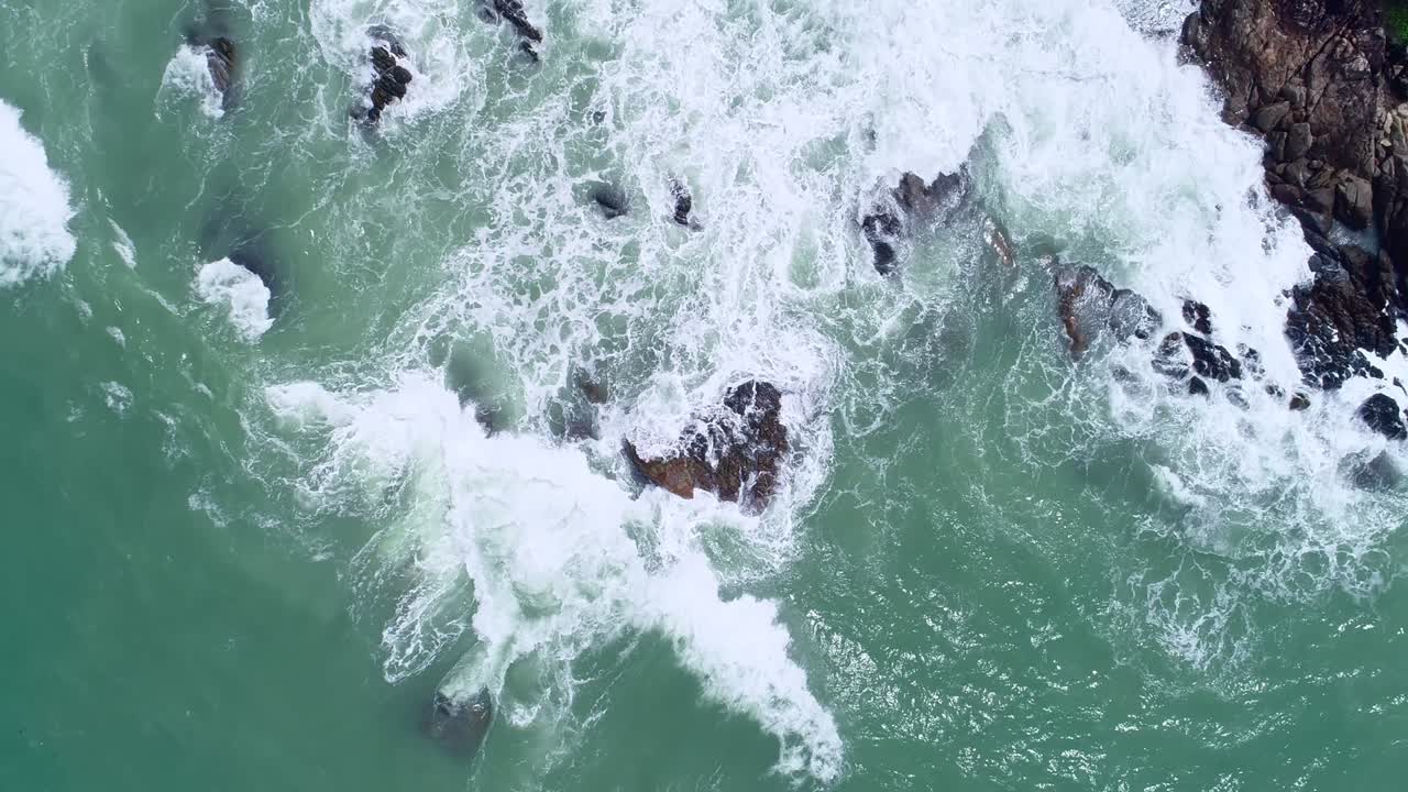 vista aérea cámara drone de arriba hacia abajo de las rocas de la orilla en el océano hermosa superficie del mar increíbles olas del mar chocando contra las rocas paisaje marítimo en la isla de phuket tailandia vista aérea drone 4k imágenes de alta calidad