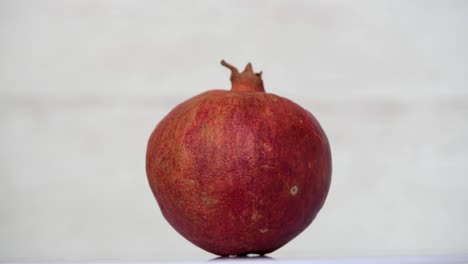 whole red pomegranate fruit spining on white