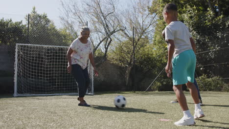 enjoying outdoor activity, african american family playing soccer together in backyard