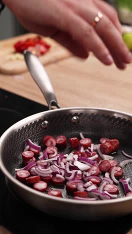 cooking sausage and onions in a pan