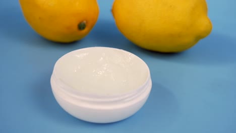 Close-up-of-petroleum-jelly-i-and-lemon-on-blue-,