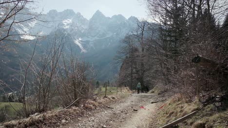 Walking-up-a-farm-dirt-track-with-gozd-Martuljek-in-the-background-in-the-northern-area-of-Slovenia