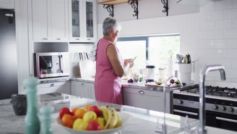 Feliz-Mujer-Birracial-Senior-Preparando-Una-Bebida-Saludable-En-La-Cocina