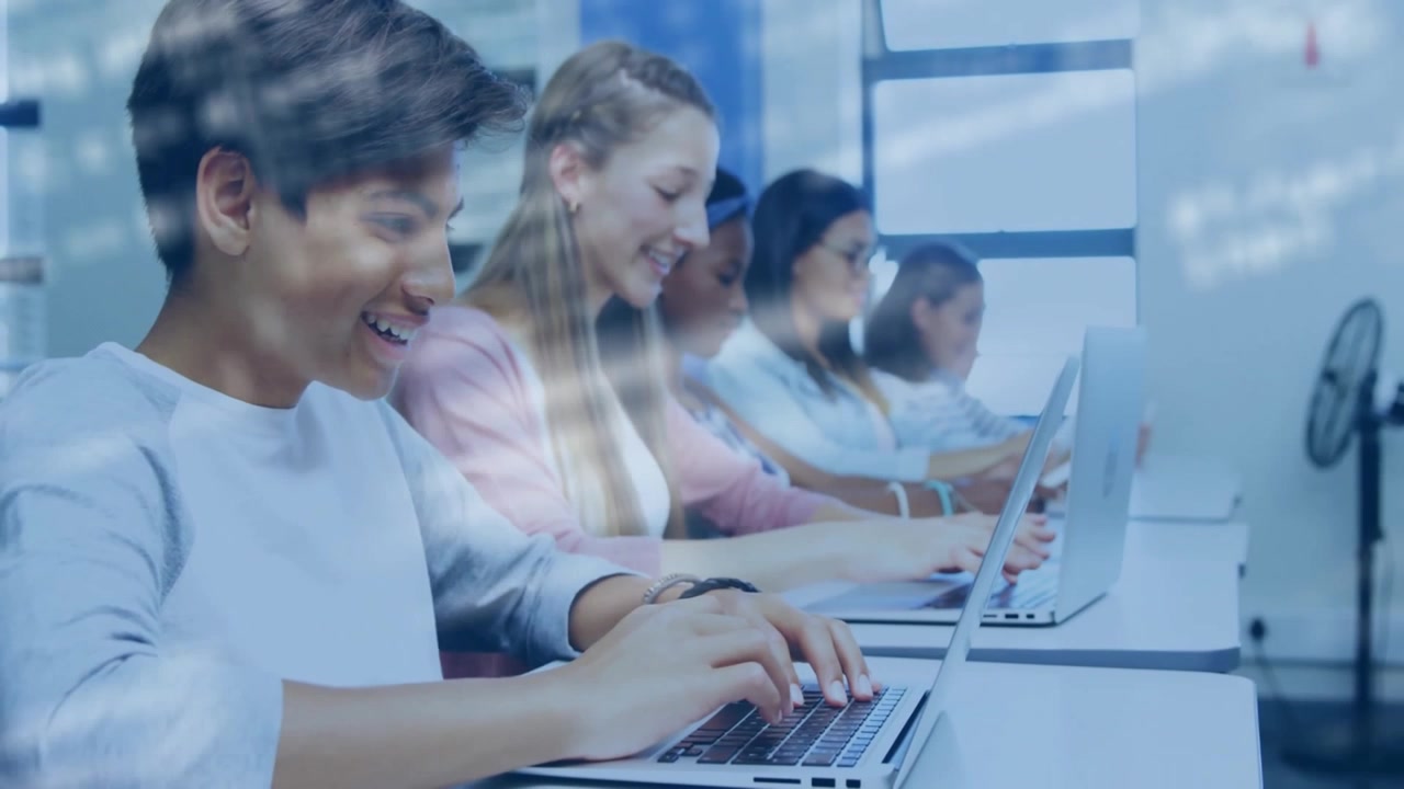 Teenage students typing on laptops in computer lab, showing floating code animation
