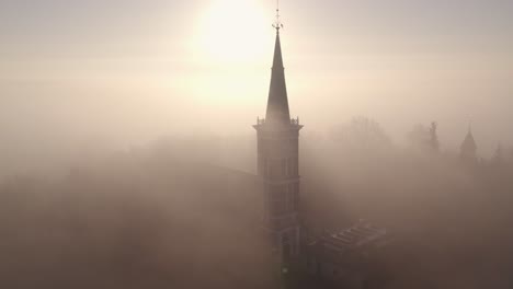 traditional dutch church at friesland with dense morning fog, aerial