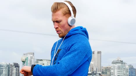 Jogger-with-headphones-checking-his-smartwatch-while-jogging,-4K-4k