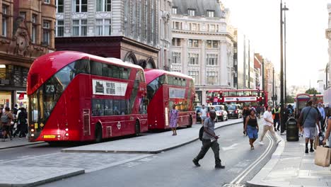 cyclist passing by red double-decker buses