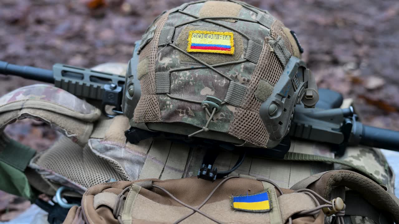 Ukraine War: Gear of a Colombian volunteer soldier in the International Legion. A helmet and rifle with Colombian and Ukrainian flag patches are seen during a combat drill