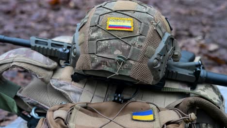 ukraine war: gear of a colombian volunteer soldier in the international legion. a helmet and rifle with colombian and ukrainian flag patches are seen during a combat drill