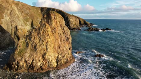 Waterford-coast-seasick-at-sunset,-the-Copper-Coast-lights-up-in-golden-colours