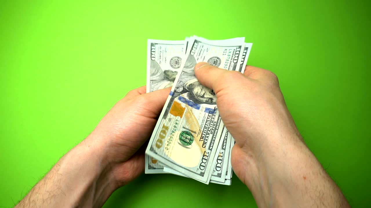 Man Counting Dollar Notes isolated on green screen background. Close up.