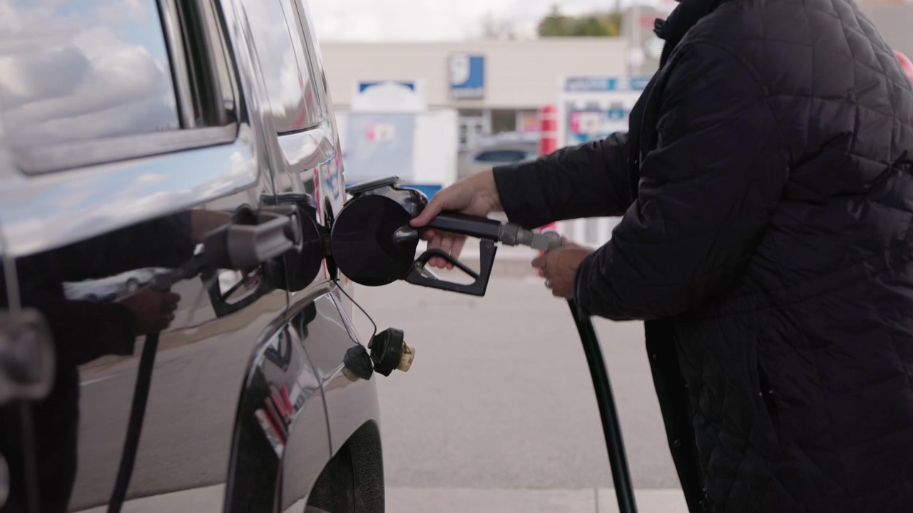 Close-Up of Person Refueling Dark SUV at Gas Station