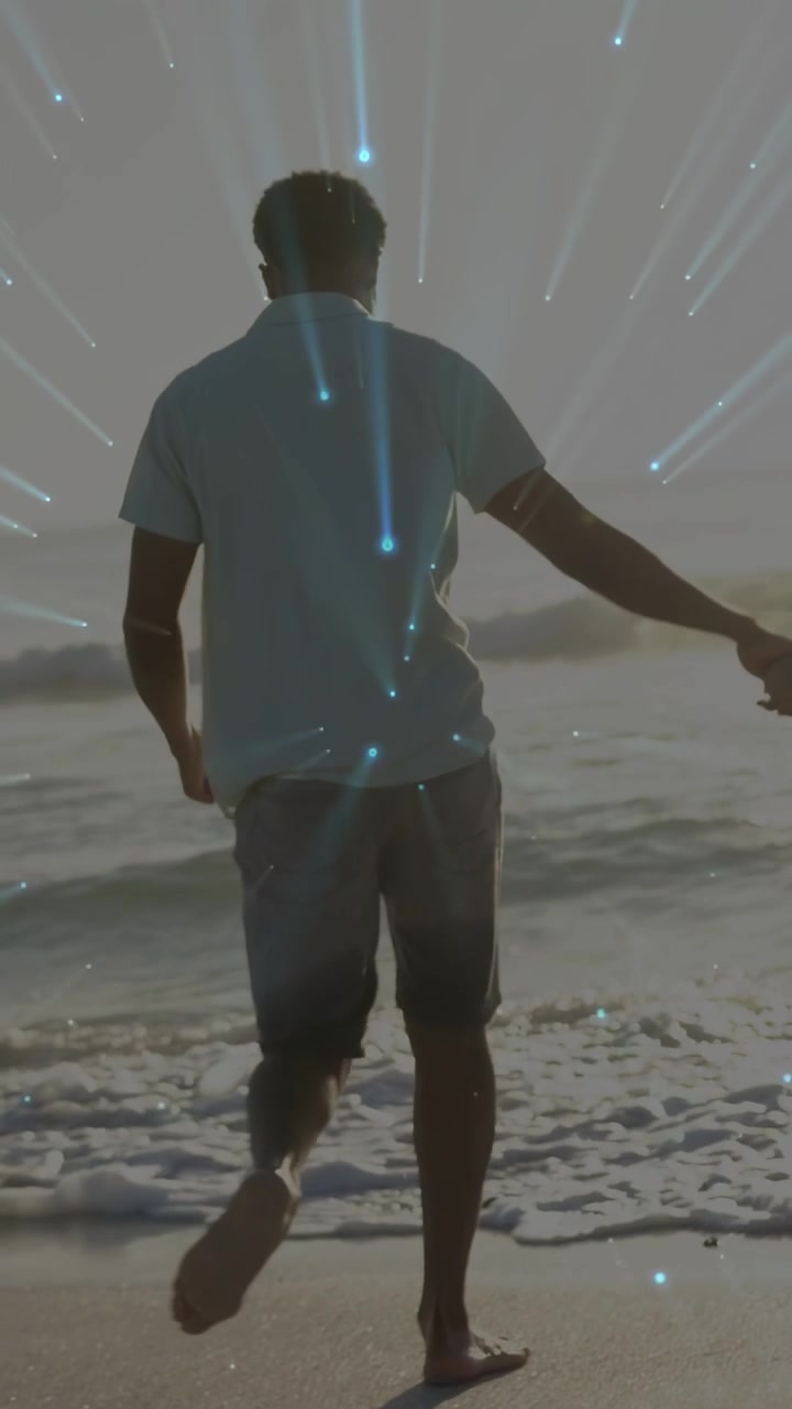 Vídeo vertical: Casal correndo enquanto as ondas se aproximam, entrando na água, rastros azuis ao redor do casal, viagem.