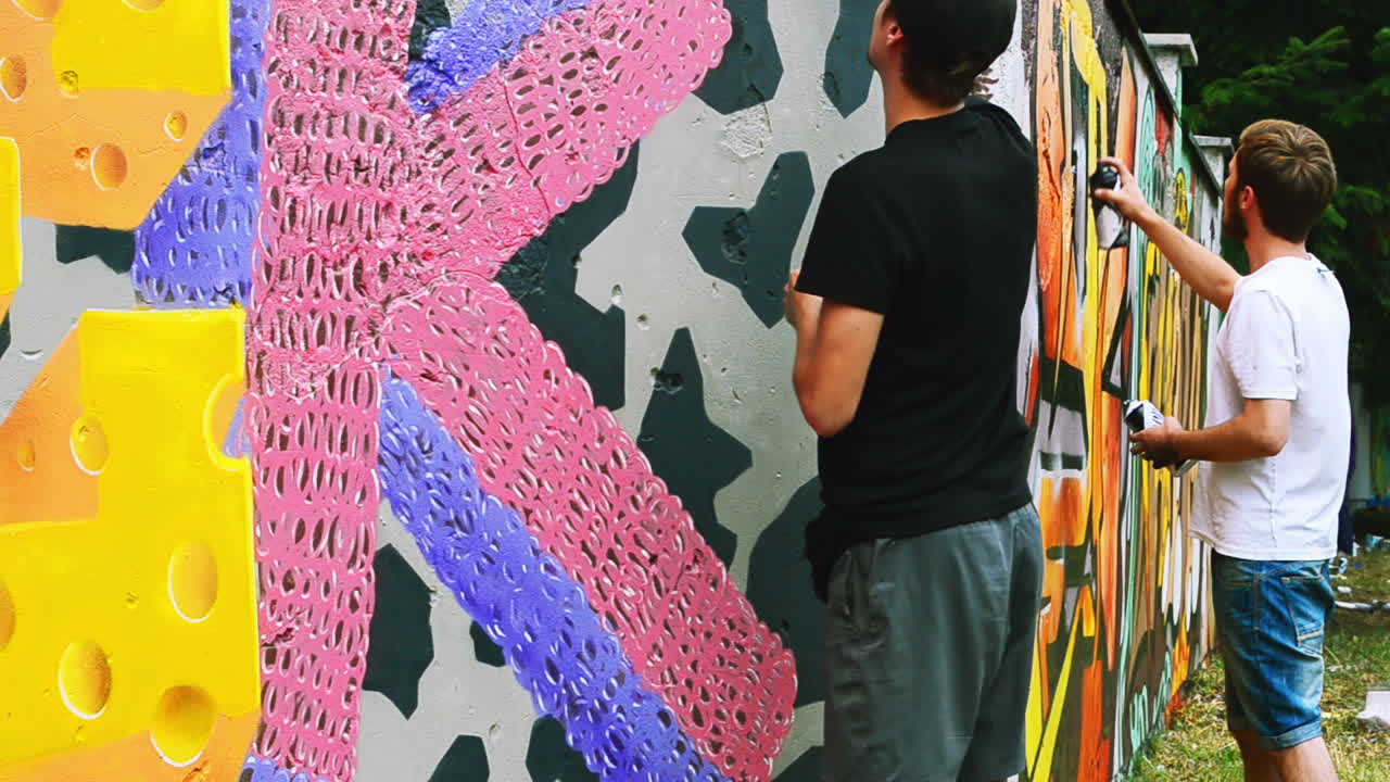 L'artista disegna graffiti su una recinzione. Disegno astratto