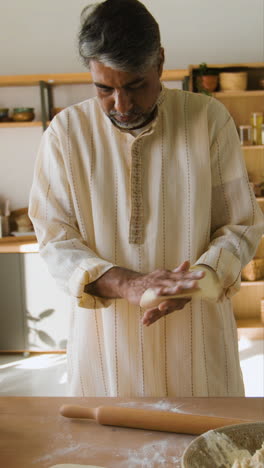 man making chapati or roti in a kitchen