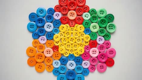 a vibrant arrangement of colorful buttons forming a hexagonal pattern, showcasing an artistic display of various shades and shapes for crafting inspiration
