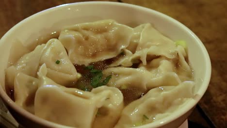 Tasting-the-broth-of-an-authentic-traditional-khmer-dumpling-noodle-soup-called-mii-kiev-and-siev-mai,-close-up