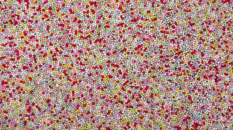 Vista dall'alto di piccoli zuccherini colorati in rotazione. Sfondo