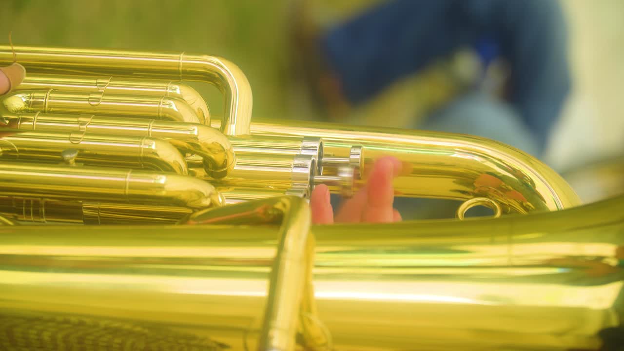 primo piano estremo di un suonatore di tuba che preme rapidamente i pulsanti senza sapere cosa sta facendo ma continua a farlo video verticale