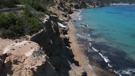 Aerial-view-over-the-beautiful-coastline-with-turqouise-ocean-water-in-Ibiza,-Spain