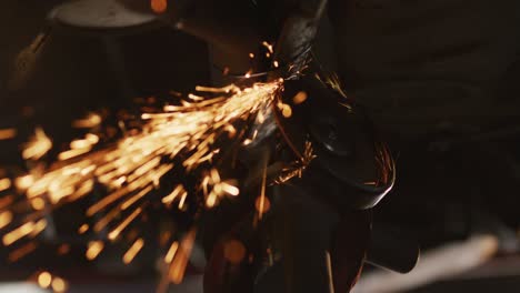 Close-up-of-female-mechanic-using-electric-blade-cutter-to-repair-a-car-at-a-car-service-station