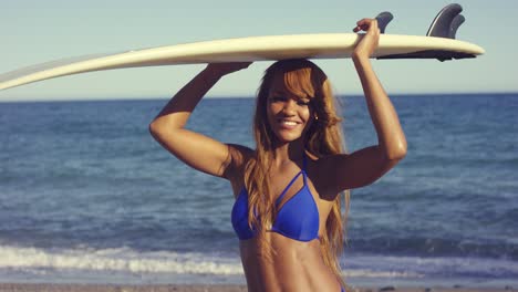 sexy afrikanische frau hält ein surfbrett über dem kopf