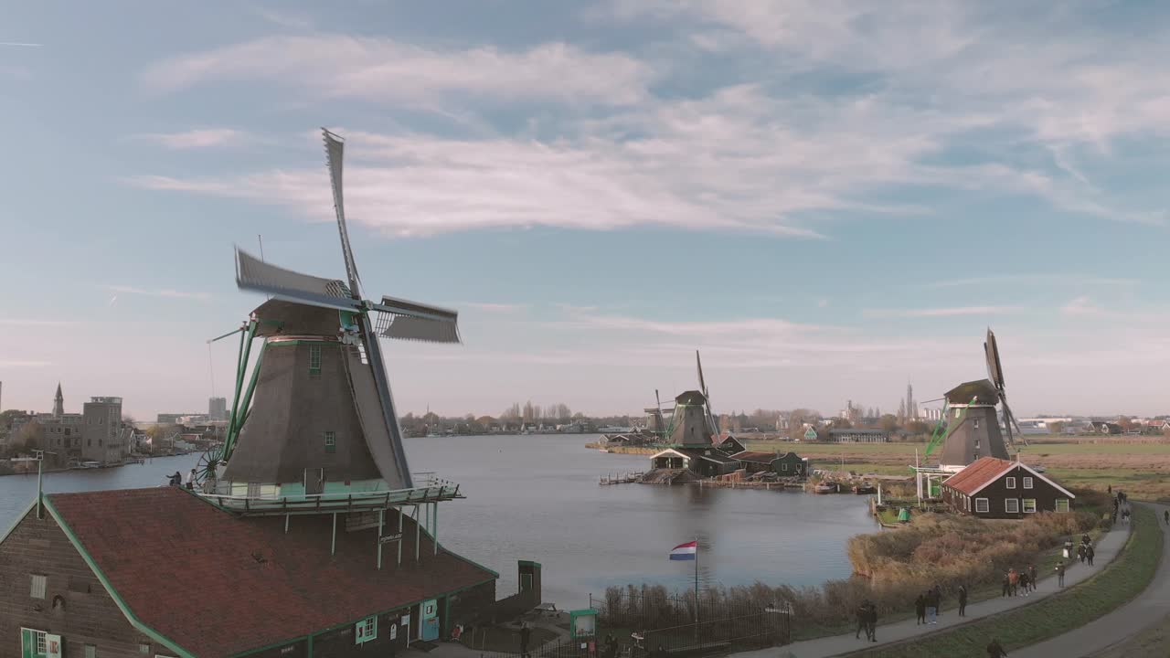 푸른 하늘이 있는 밝은 날에 다른 풍차와 회전 심지가 있는 전형적인 네덜란드 풍경의 풍차를 보여주는 지상에서 패닝