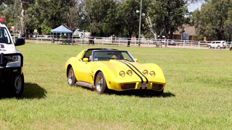 a yellow sports car overtakes a black suv on grass.