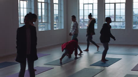 yoga-class-of-young-women-preparing-for-ealy-morning-workout-getting-ready-in-fitness-studio-at-sunrise