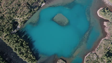 aerial over lake with turquoise blue water, natural landscape captured during daytime, untouched nature concept